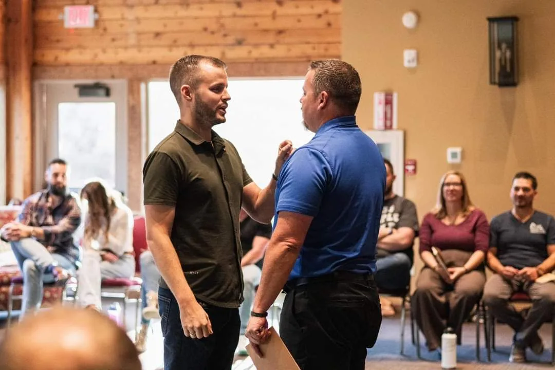 Austin coaching a man in front of a live audience